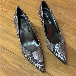 Bandolier snakeskin print heels.  These are made with man-made materials.